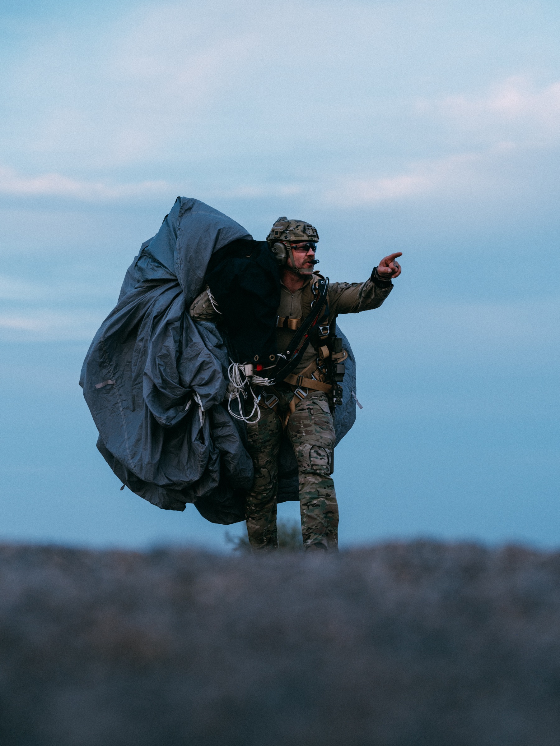 Outer Heaven Foundation operator after blue-hour landing, parachute trailing
